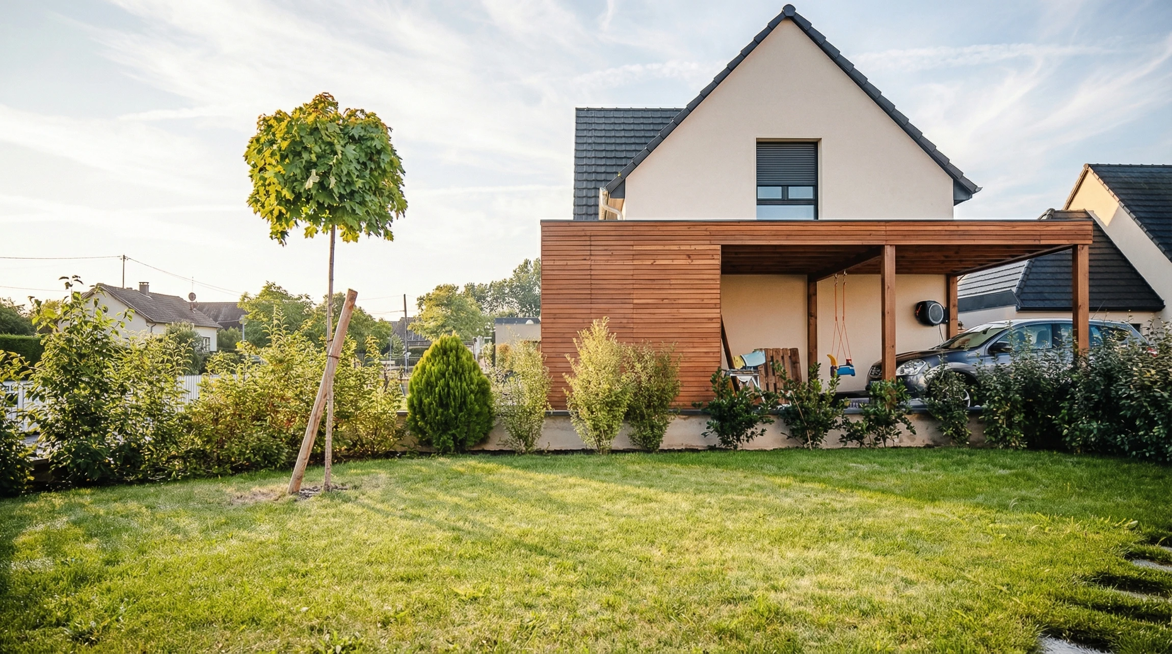 Jardin contemporain avec terrasse en bois composite, deux fauteuils Acapulco bleu turquoise et noir sur structure métallique